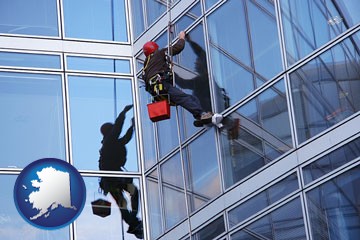 a window washer, washing office building windows - with Alaska icon