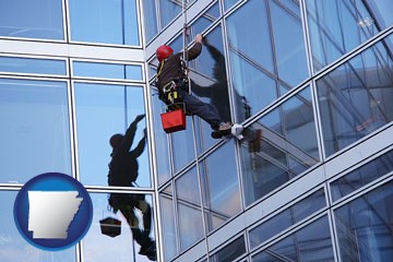a window washer, washing office building windows - with Arkansas icon