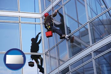 a window washer, washing office building windows - with Kansas icon
