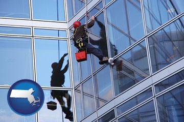 a window washer, washing office building windows - with Massachusetts icon