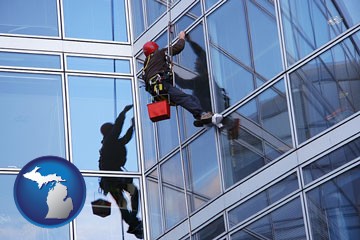 a window washer, washing office building windows - with Michigan icon