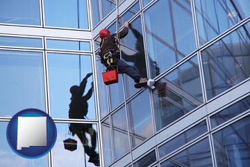 a window washer, washing office building windows - with New Mexico icon