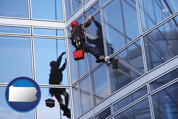 a window washer, washing office building windows - with Pennsylvania icon