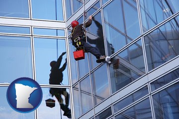 a window washer, washing office building windows - with Minnesota icon